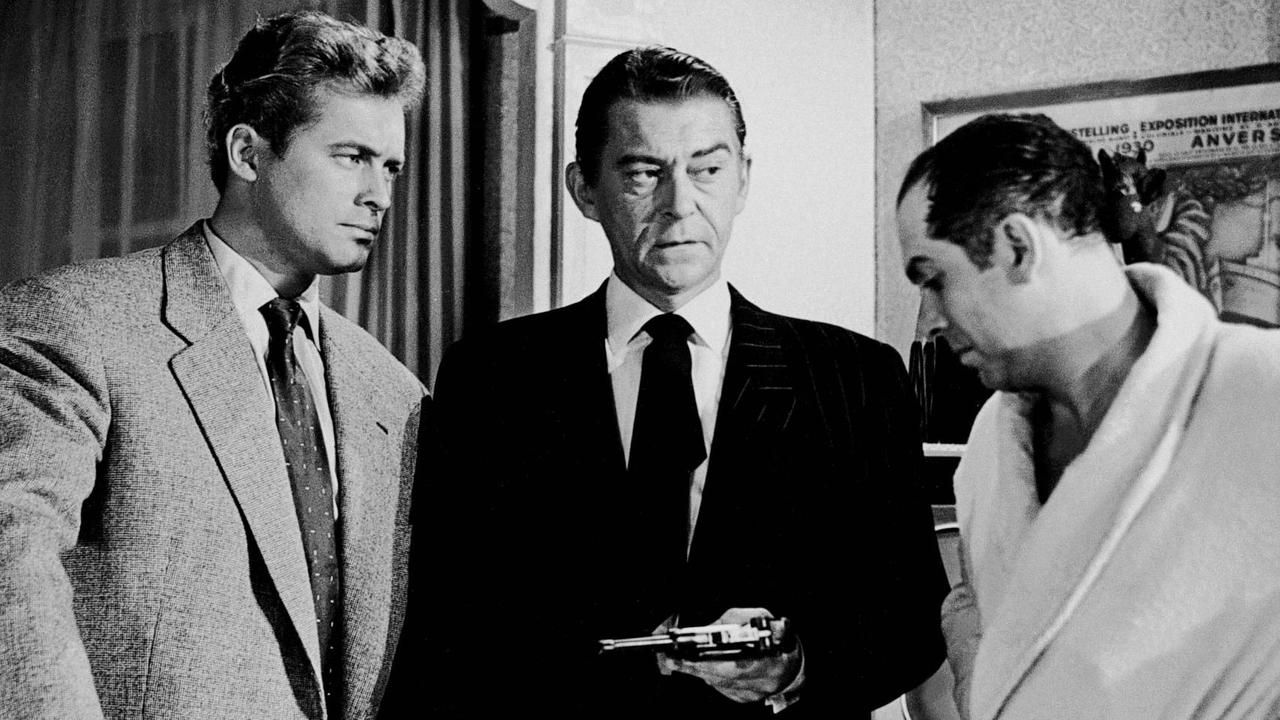 Szene aus dem Film "Rififi" (1955) von Jules Dassin. Drei Männer stehen zusammen und schmieden einen Plan. Der in der Mitte hält eine Waffe in der Hand.
