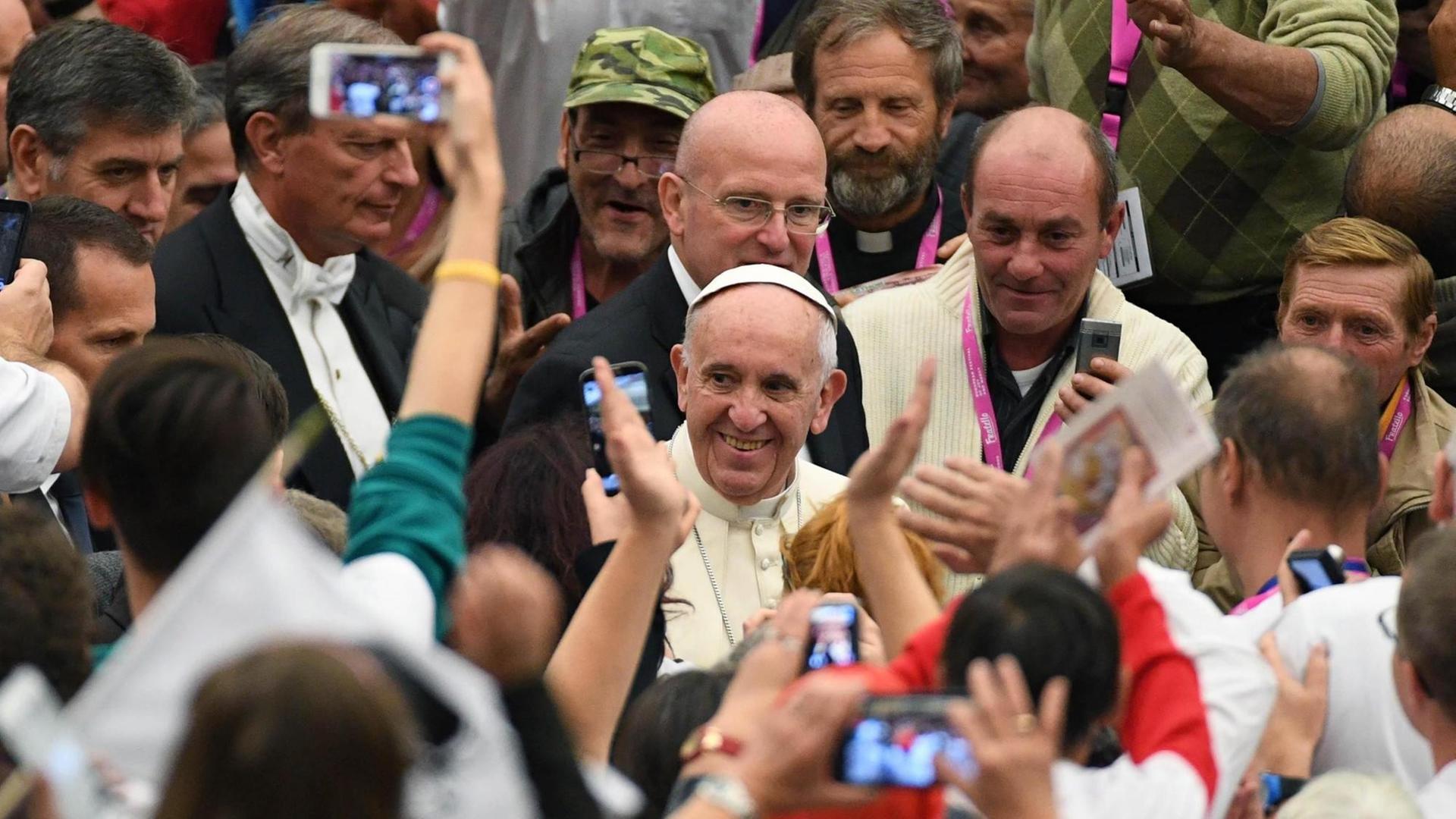 Papst Franziskus in einer Gruppe von Obdachlosen, die er zu einer Audienz im Vatikan empfangen hat. Papst Franziskus in einer Gruppe von Obdachlosen, die er zu einer Audienz im Vatikan empfangen hat.