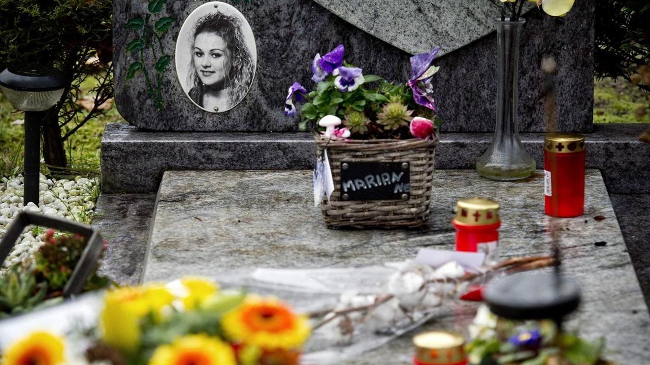 Blumen am grauen Grabstein von Marianna Vaatstra. Zu sehen ist auch ein Foto des ermordeten Mädchens.