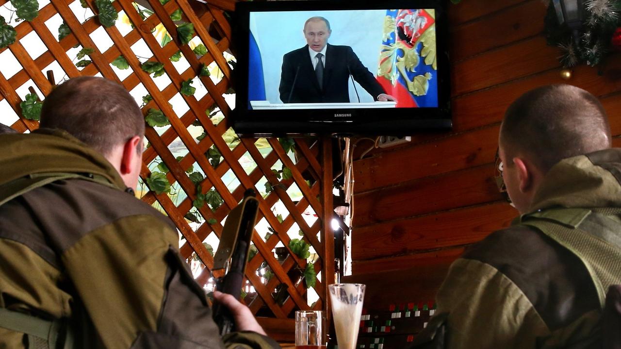 Soldaten schauen eine Putin-Rede im Fernsehen Soldaten schauen eine Putin-Rede im Fernsehen