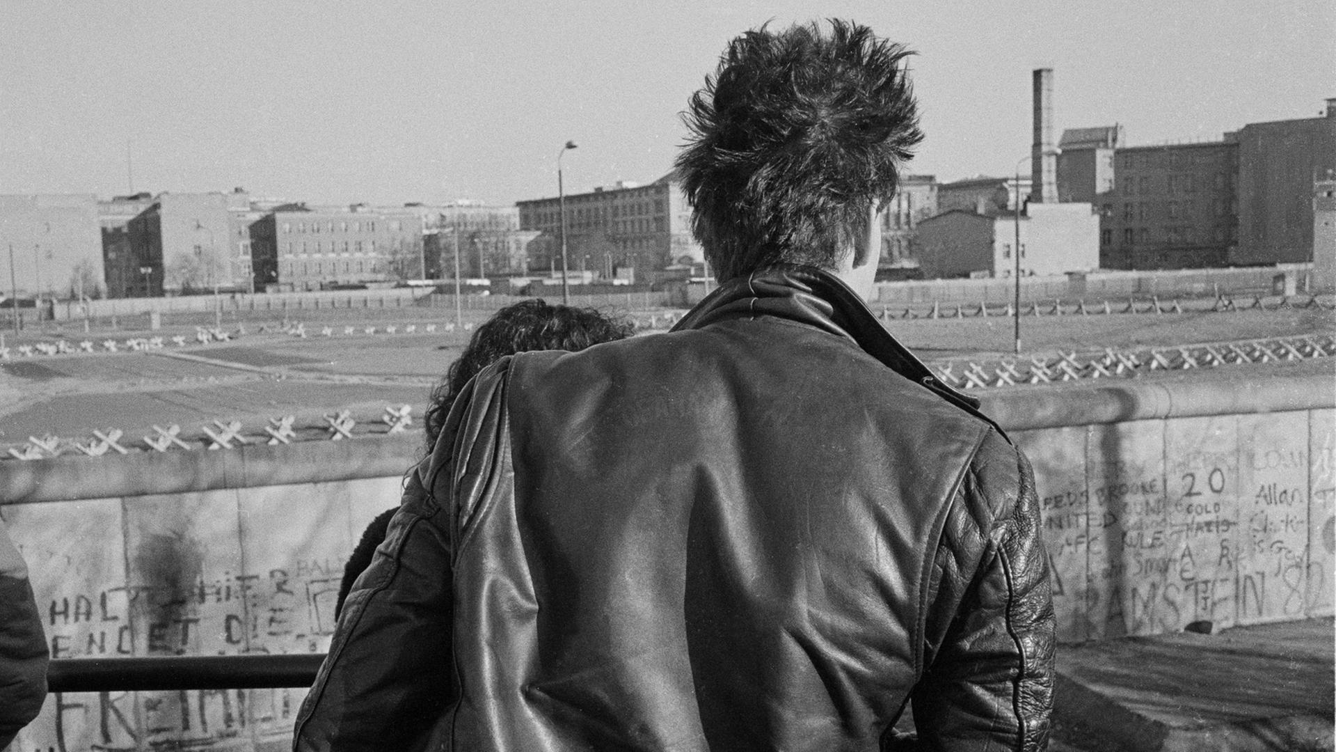 Besucher auf der Aussichtsplattform am Potsdamer Platz blicken im Jahr 1982 über die Berliner Mauer nach Ostberlin. Besucher auf der Aussichtsplattform am Potsdamer Platz blicken im Jahr 1982 über die Berliner Mauer nach Ostberlin.