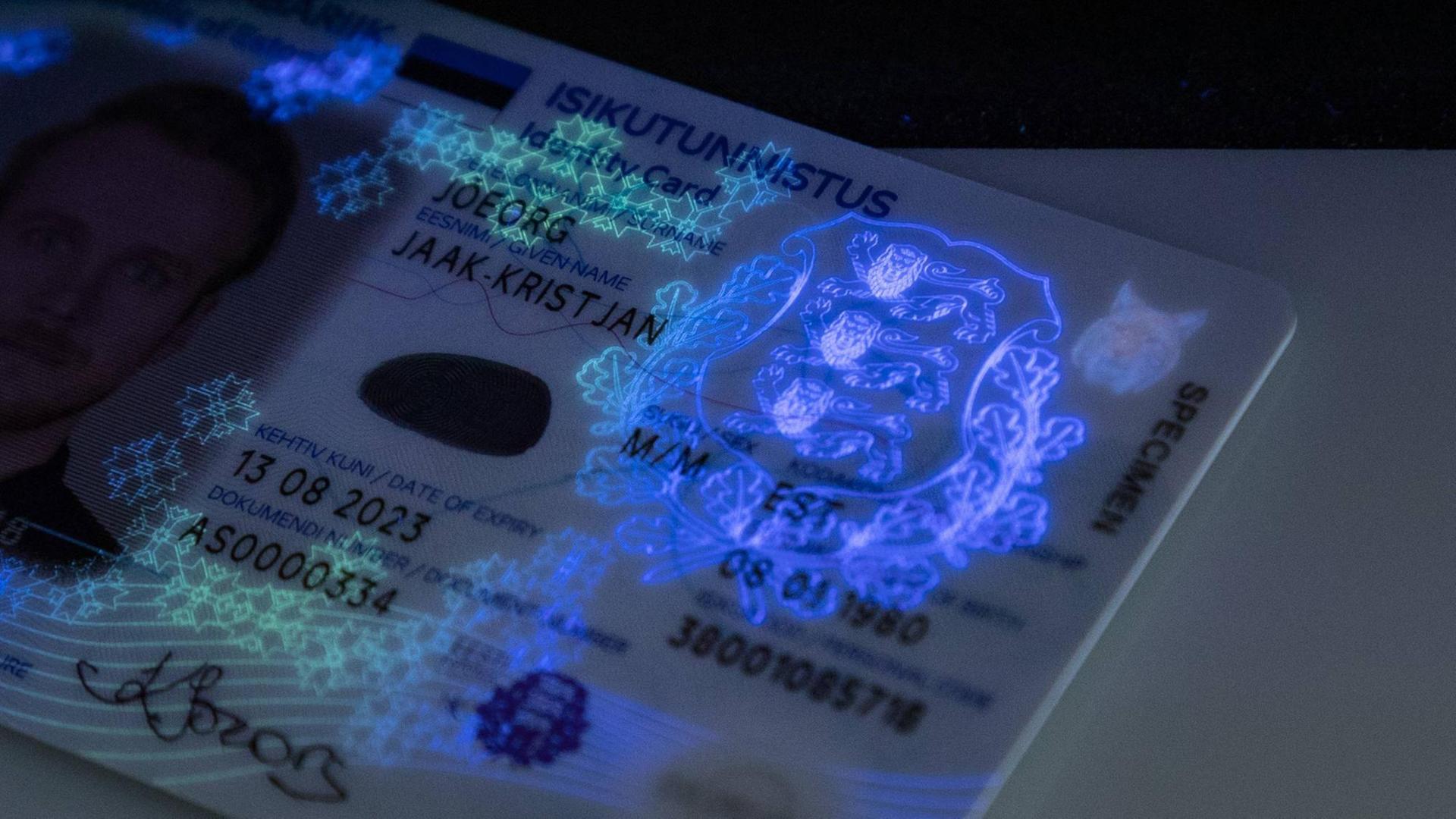 Ein durch Schwarzlicht beleuteter Personalausweis zeigt die bei normalen Licht verborgenen Sicherheitsbilder.