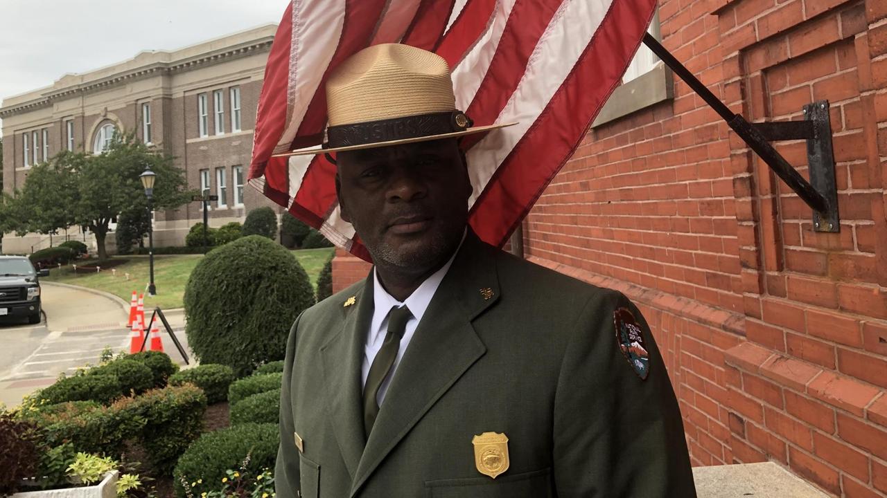 Terry E. Brown, der Leiter des Fort Monroe National Monument, steht vor einer Fahne Terry E. Brown, der Leiter des Fort Monroe National Monument, steht vor einer Fahne
