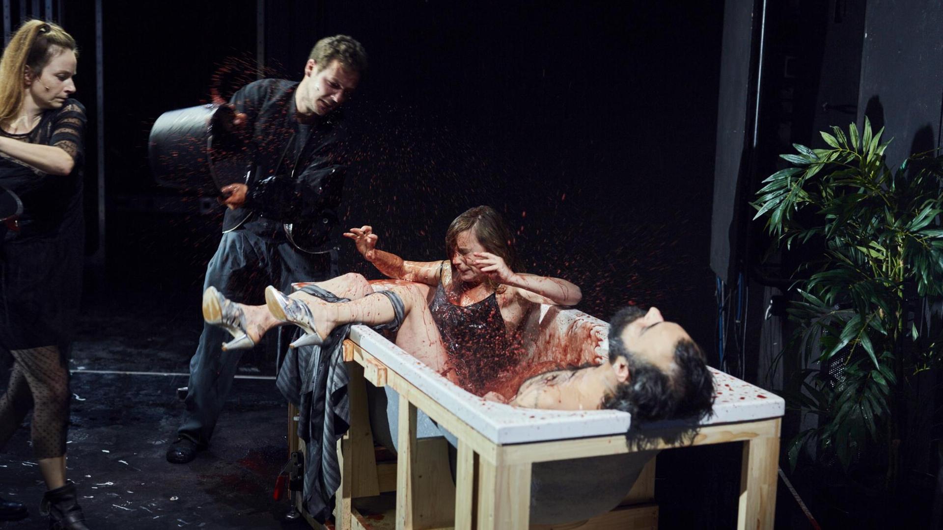 Ein Mann kippt Blut in eine Wanne mit zwei Personen. Ein Mann kippt Blut in eine Wanne mit zwei Personen.