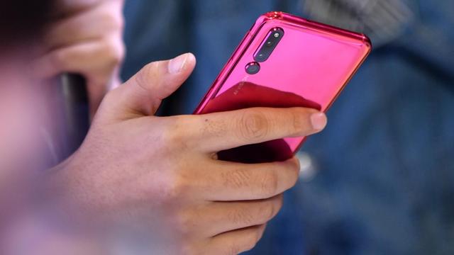 Ein Nutzer sieht sich das "Honor Magic 2 Smartphone" des chinesischen Unternehmens Huawei an. Das Gerät wurde im Oktober 2018 in Peking vorgestellt.