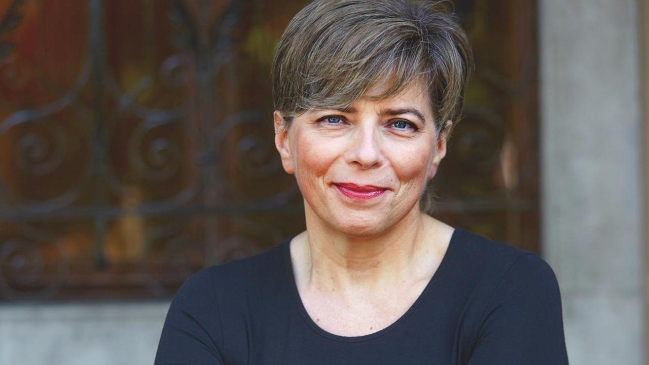Raffaella Romagnolo sitzt auf einem Stuhl und blickt den Betrachter an. Raffaella Romagnolo sitzt auf einem Stuhl und blickt den Betrachter an.