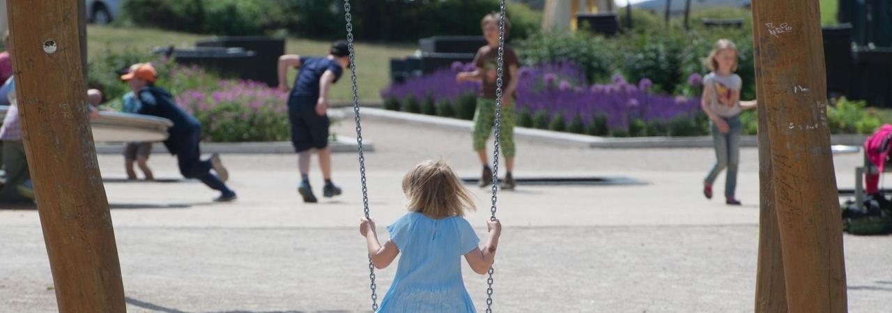 Ein Mädchen sitzt auf einem Spielplatz in Erfurt (Thüringen) auf einer Schaukel. Ein Mädchen sitzt auf einem Spielplatz in Erfurt (Thüringen) auf einer Schaukel.