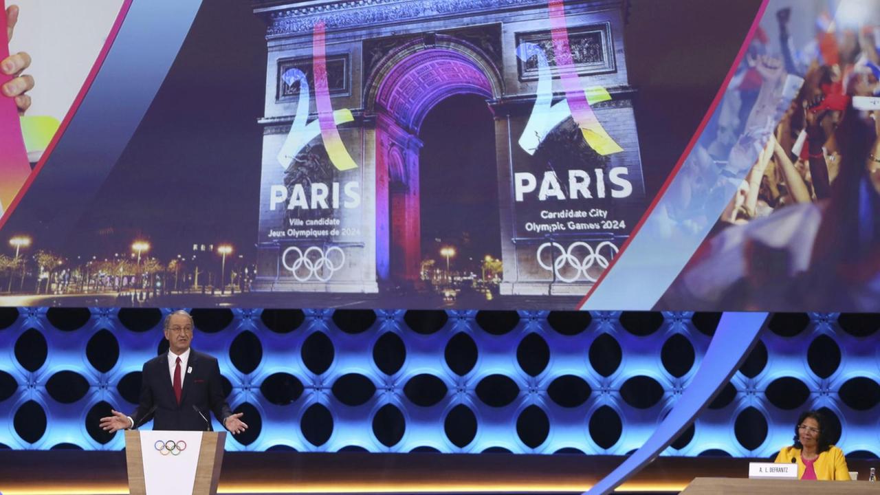 Das Bild zeigt im Hintergrund den Triumphbogen in Paris. Vorne redet der Vorsitzende des französischen Nationalen Olympischen Komitees (CNOSF), Denis Masseglia am 13.09.2017 auf der IOC-Vollversammlung in Lima (Peru). Das Bild zeigt im Hintergrund den Triumphbogen in Paris. Vorne redet der Vorsitzende des französischen Nationalen Olympischen Komitees (CNOSF), Denis Masseglia am 13.09.2017 auf der IOC-Vollversammlung in Lima (Peru).