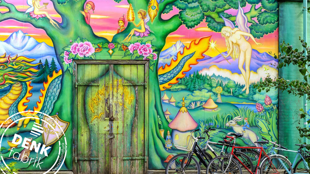 Fahrräder stehen vor einem riesigen bunten Graffiti an einer Hauswand in der alternativen Wohnsiedlung "Freistadt Christiania" in Dänemarks Hauptstadt Kopenhagen