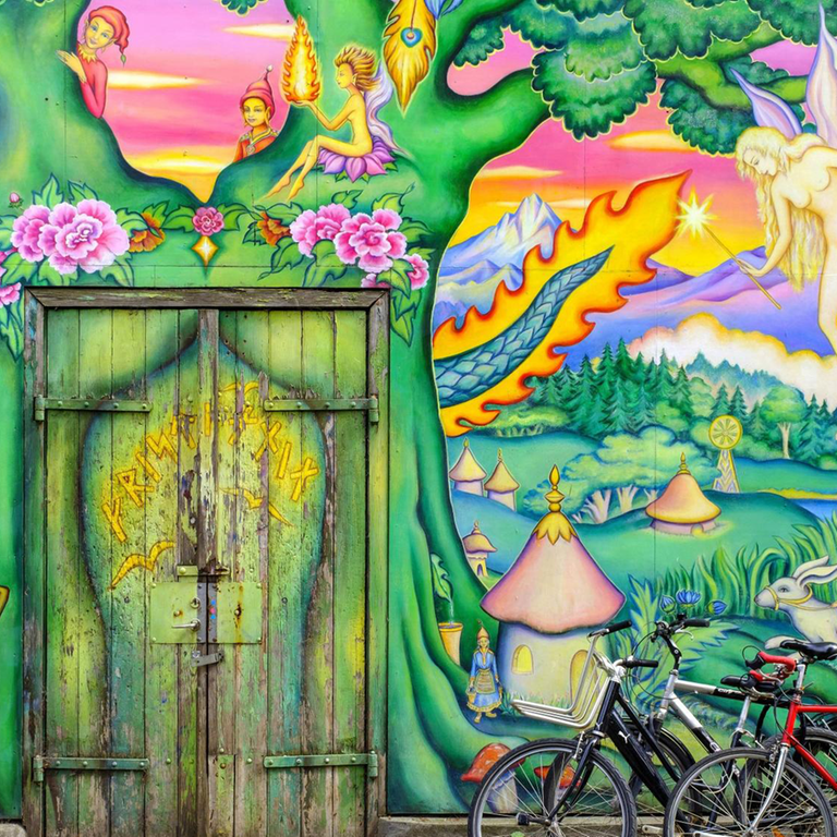 Fahrräder stehen vor einer Hauswand mit Graffiti in der alternativen Wohnsiedlung 