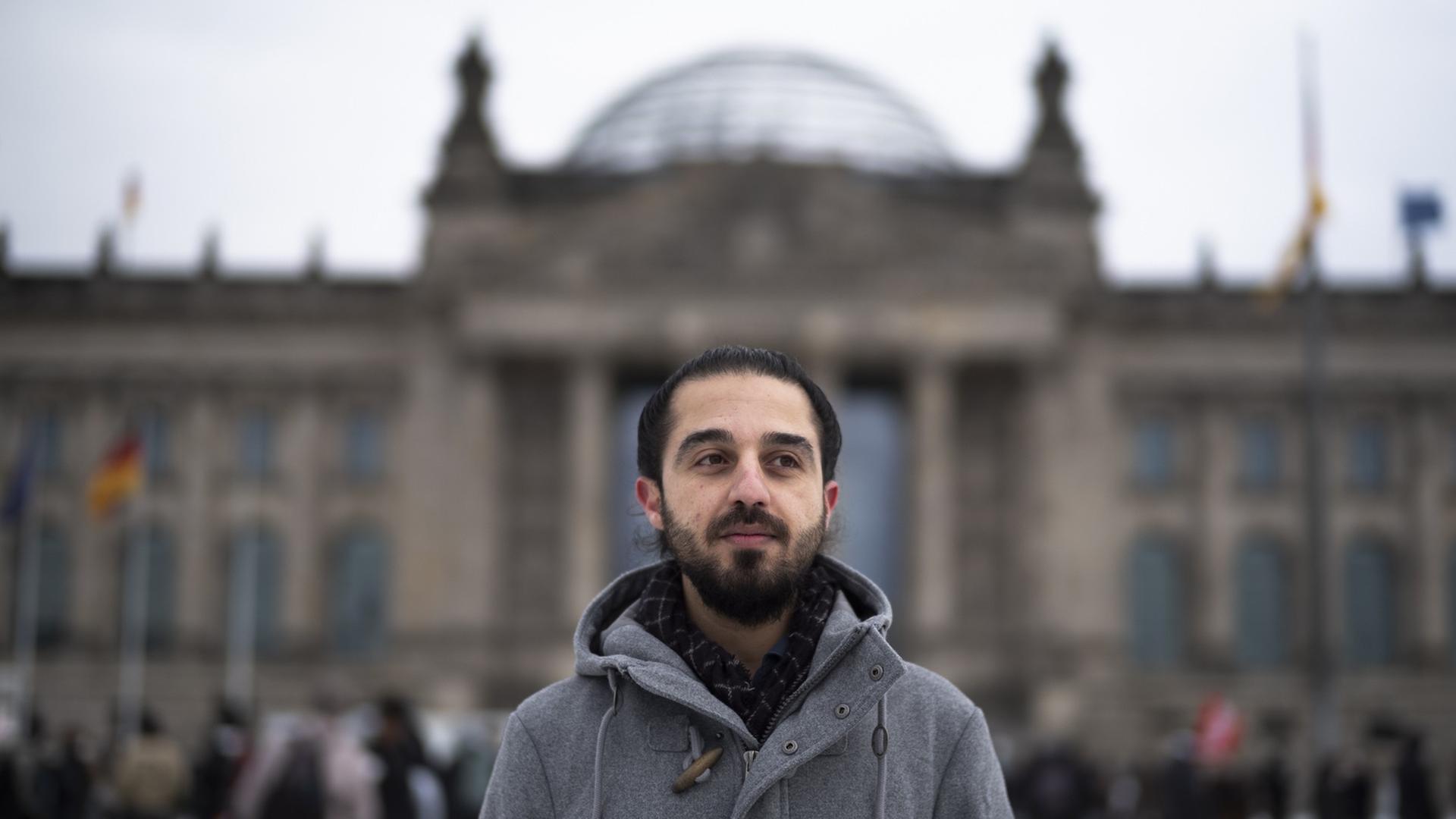Der Grünen-Politiker Tareq Alaows vor dem Reichstagsgebäude in Berlin. Der Grünen-Politiker Tareq Alaows vor dem Reichstagsgebäude in Berlin.