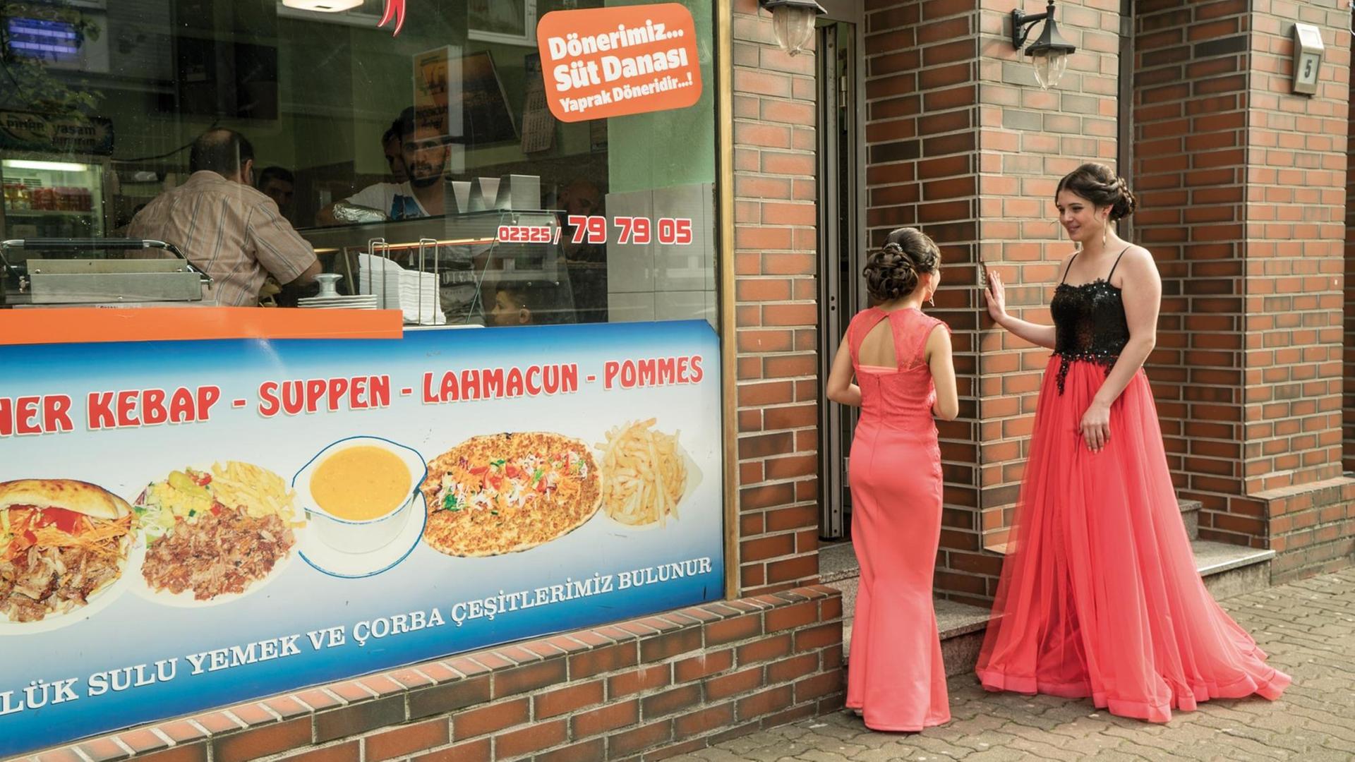 Zwei festlich gekleidete Junge Frauen stehen vor einem Döner-Imbiss in Herne-Wanne Zwei festlich gekleidete Junge Frauen stehen vor einem Döner-Imbiss in Herne-Wanne