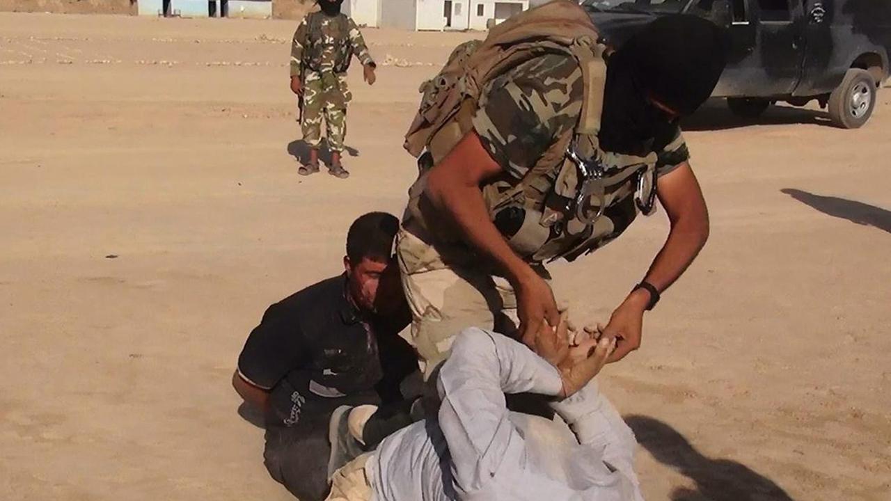 Das Bild zeigt angeblich einen Kämpfer des IS, der einen irakischen Soldaten fesselt - die Echtheit lässt sich nicht prüfen Das Bild zeigt angeblich einen Kämpfer des IS, der einen irakischen Soldaten fesselt - die Echtheit lässt sich nicht prüfen