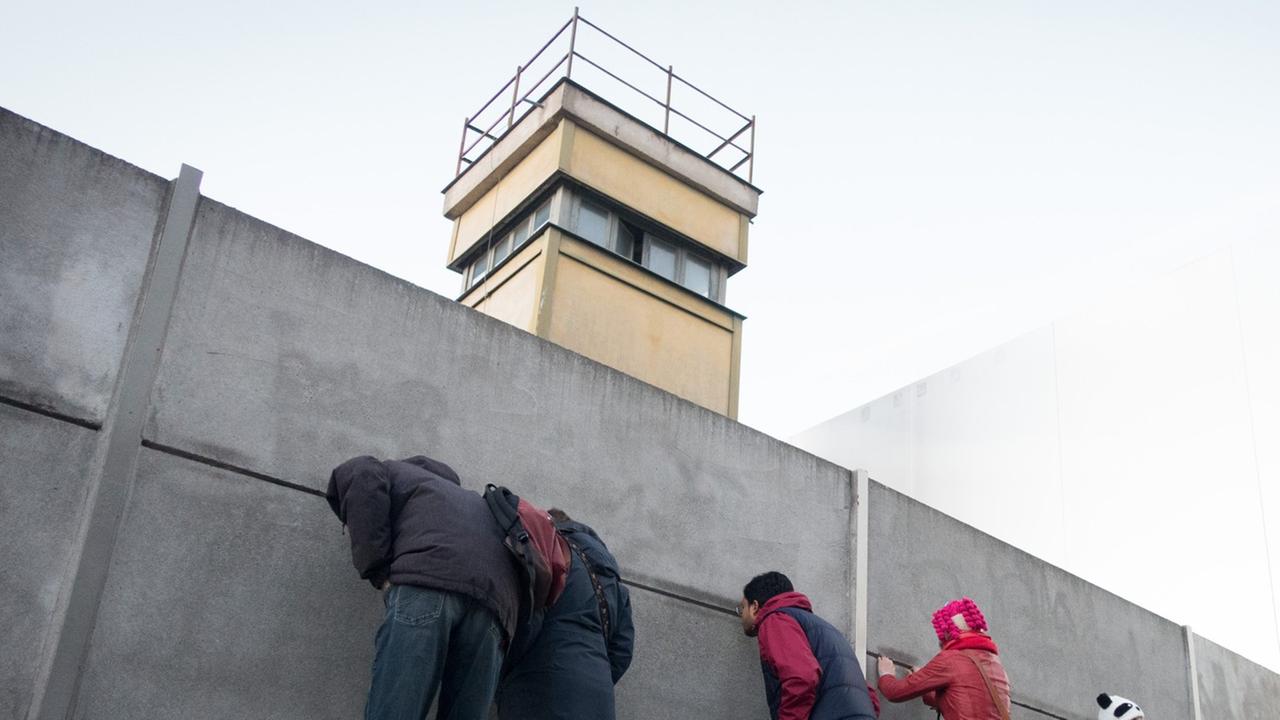 Passanten stehen an der Mauergedenkstätte in Berlin. Passanten stehen an der Mauergedenkstätte in Berlin.