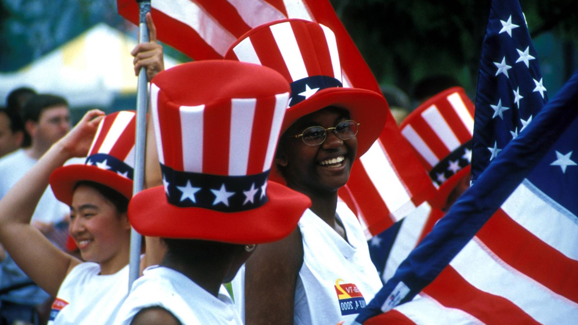 Schwarze Amerikanerinnen in Atlanta im US-Bundesstaat Georgia mit Stars-and-Stripes-Zylindern und Nationalflaggen Schwarze Amerikanerinnen in Atlanta im US-Bundesstaat Georgia mit Stars-and-Stripes-Zylindern und Nationalflaggen