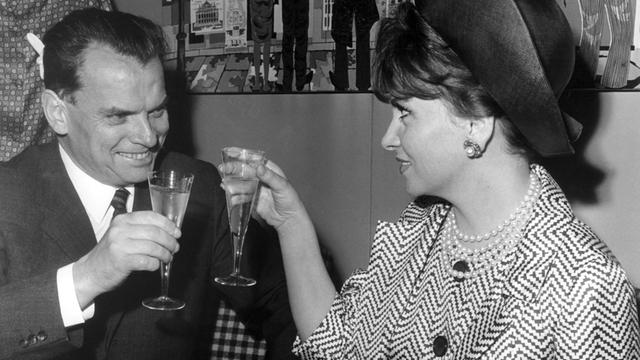 Der Berlinale-Festspielleiter Afred Bauer begrüßt die italienische Schauspielerin Gina Lollobrigida nach ihrer Ankunft auf dem Flughafen Tegel in Berlin am 02.07.1965 mit einem Glas Sekt