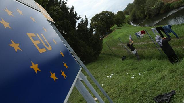 Zwei Frauen hängen im Grenzgebiet zwischen Slowenien und Kroatien Wäsche auf.