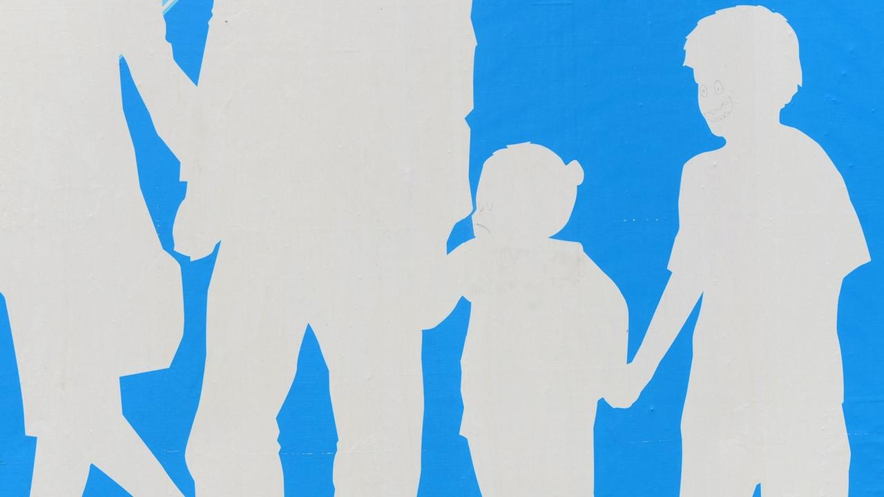 Auf blauem Hintergrund sind die Silhouetten einer Familie mit Mutter, Vater, Tochter und Sohn in weiß zu sehen. Auf blauem Hintergrund sind die Silhouetten einer Familie mit Mutter, Vater, Tochter und Sohn in weiß zu sehen.