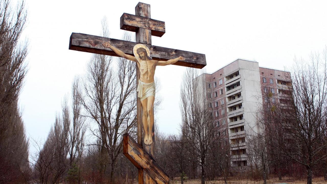 Leer stehendes Hochhaus und christliches Kreuz in der Geisterstadt Pripjat