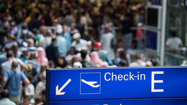 Reisende stehen in einer langen Schlange vor der Sicherheitskontrolle im Terminal 2 des Flughafens in Frankfurt am Main