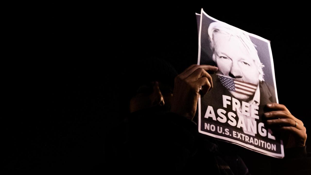 Protestierende in Paris am 05.11.2019 beim "Million Mask March" halten ein Schild von Julian Assange in die Höhe, auf dem er mit der amerikanischen Fahne geknebelt ist. Protestierende in Paris am 05.11.2019 beim "Million Mask March" halten ein Schild von Julian Assange in die Höhe, auf dem er mit der amerikanischen Fahne geknebelt ist.