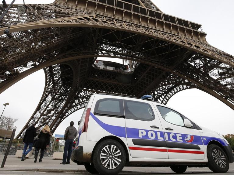 Ein Polizeiauto passiert in Frankreich den Eiffel-Turm.