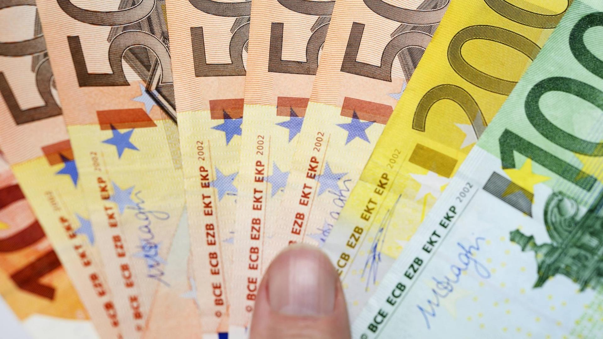 Eine Hand hält Euro-Geldscheinwie einen Fächer. | Verwendung weltweit Eine Hand hält Euro-Geldscheinwie einen Fächer. | Verwendung weltweit
