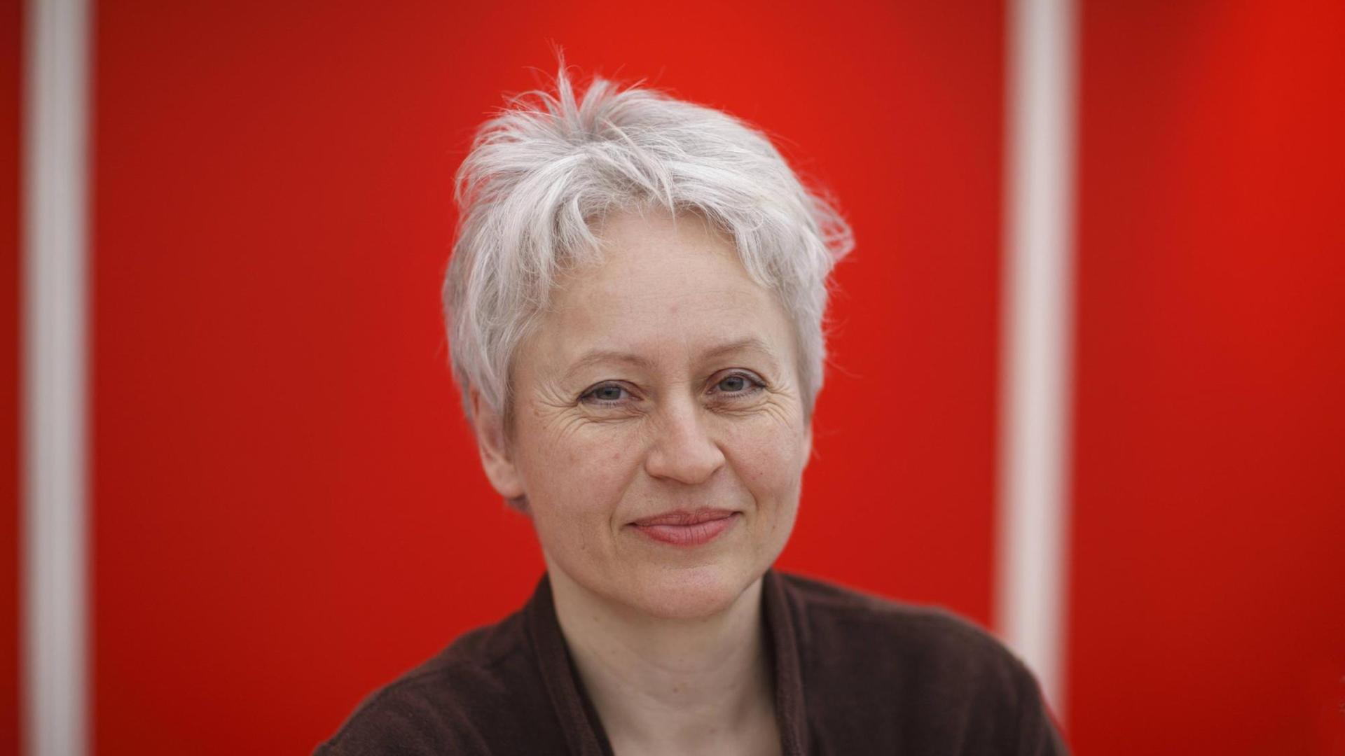 Die Schriftstellerin und Lyrikerin Ulrike Draesner im Porträt vor rotem Hintergrund, eine Aufnahme von der Leipziger Buchmesse 2011 Die Schriftstellerin und Lyrikerin Ulrike Draesner im Porträt vor rotem Hintergrund, eine Aufnahme von der Leipziger Buchmesse 2011