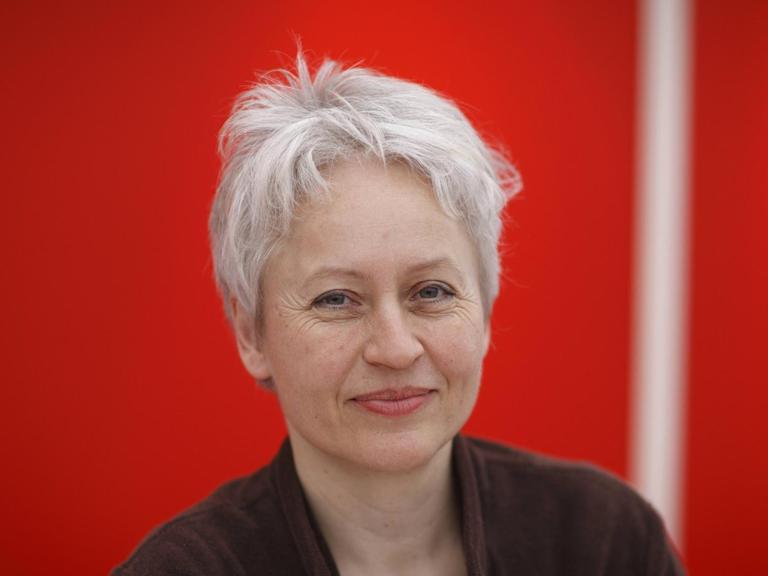 Die Schriftstellerin und Lyrikerin Ulrike Draesner im Porträt vor rotem Hintergrund, eine Aufnahme von der Leipziger Buchmesse 2011