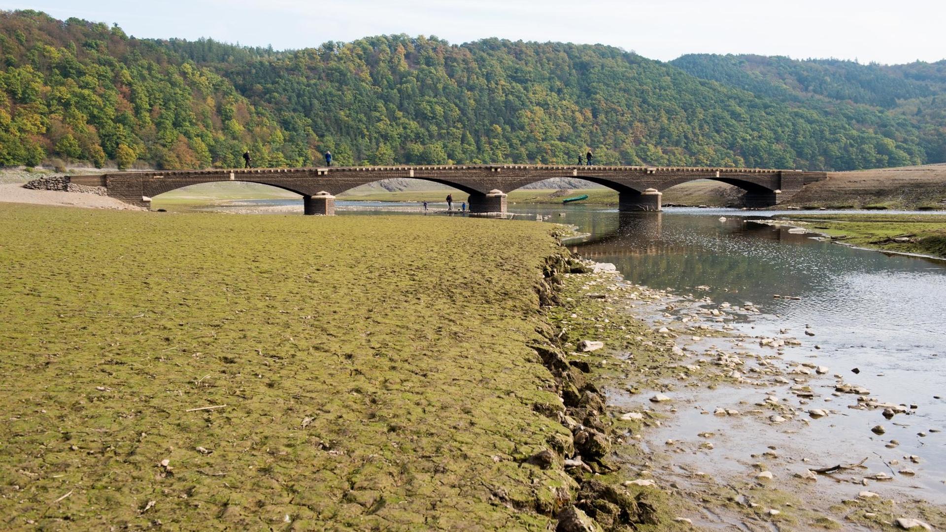 Touristen gehen am 14.10.2016 über die alte, etwa 60 Meter lange "Aseler Brücke" im Edersee (Landkreis Waldeck-Frankenberg, Hessen). Bei niedrigem Wasserstand im Edersee tauchen regelmäßig Reste alter Siedlungen auf. Touristen gehen am 14.10.2016 über die alte, etwa 60 Meter lange "Aseler Brücke" im Edersee (Landkreis Waldeck-Frankenberg, Hessen). Bei niedrigem Wasserstand im Edersee tauchen regelmäßig Reste alter Siedlungen auf.