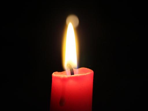 Eine rote brennende Kerze.