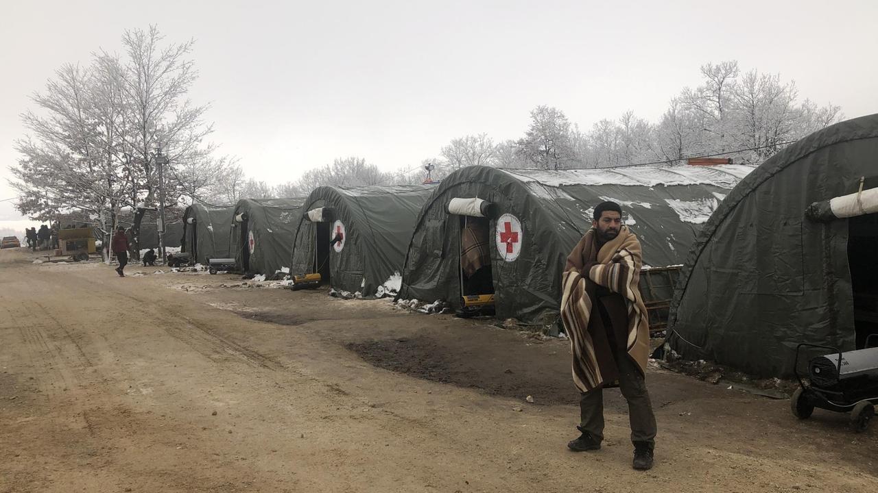 Flüchtlingscamp Lipa in Bosnien: Mann vor Zelten. Flüchtlingscamp Lipa in Bosnien: Mann vor Zelten.