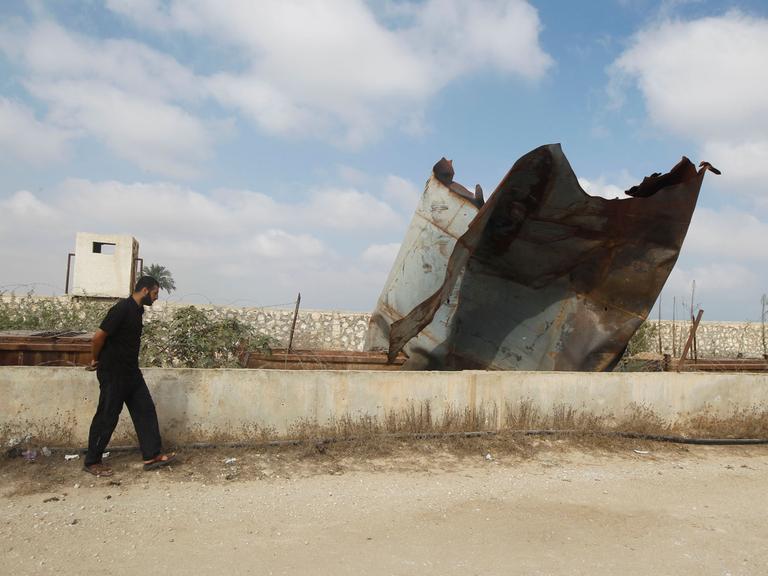 Ein Palästinenser untersucht die Schäden durch israelische Angriffe in der Stadt Rafah, während er an der Grenze zwischen Ägypten und dem Gazastreifen entlang läuft.