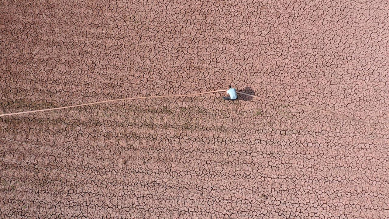 Ein Landwirt in China auf seinem vertrockneten Boden aufgenommen aus Vogelperspektive Ein Landwirt in China auf seinem vertrockneten Boden aufgenommen aus Vogelperspektive