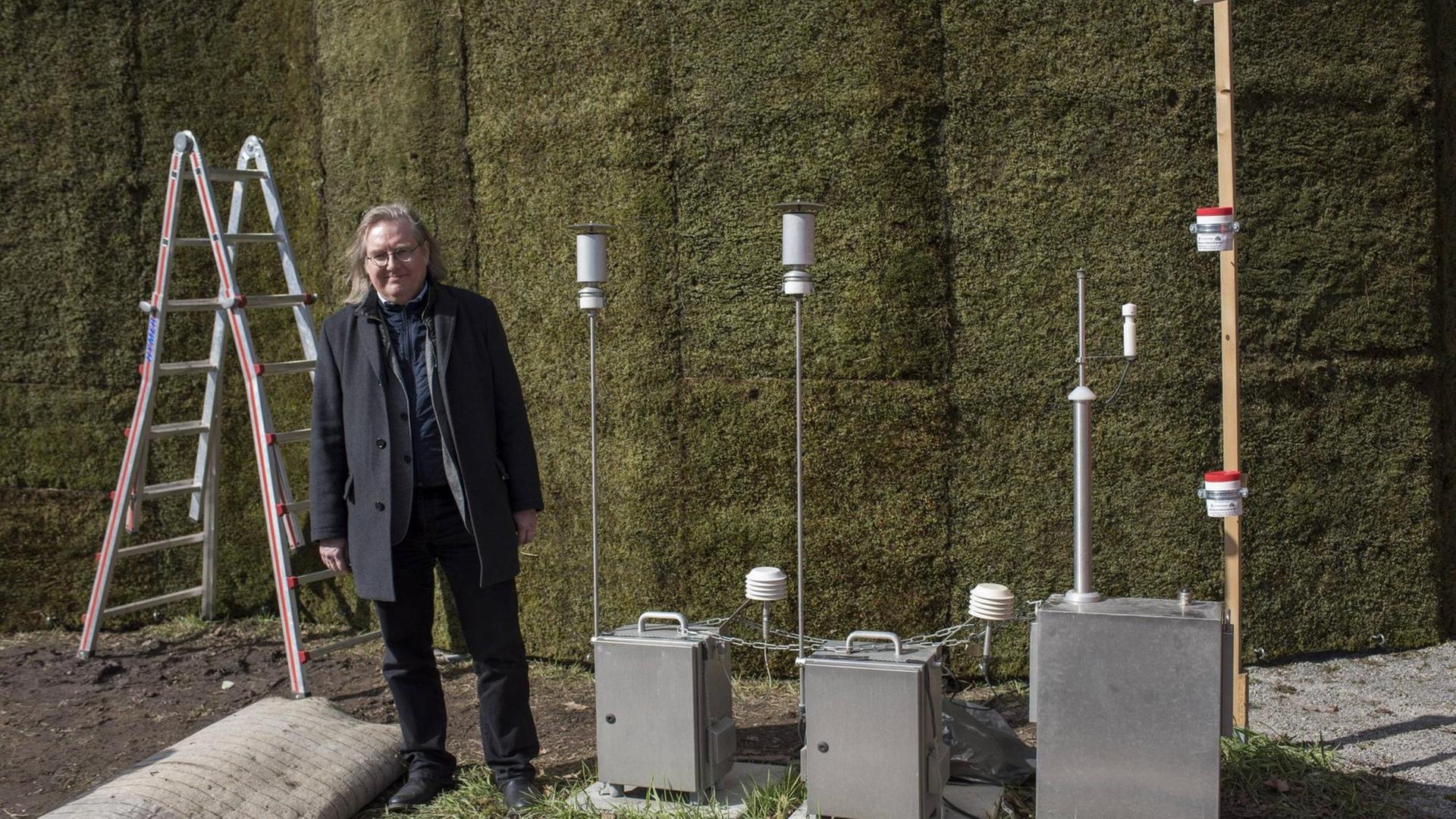 Erstmals in Baden-Württemberg ist eine Wand mit Moosen errichtet worden, um Schadstoffe und Feinstaub aus der Luft zu filtern. Die Mooswand steht an der B 14 / Cannstatter Straße. Bürgermeister Peter Pätzold direkt davor. Erstmals in Baden-Württemberg ist eine Wand mit Moosen errichtet worden, um Schadstoffe und Feinstaub aus der Luft zu filtern. Die Mooswand steht an der B 14 / Cannstatter Straße. Bürgermeister Peter Pätzold direkt davor.