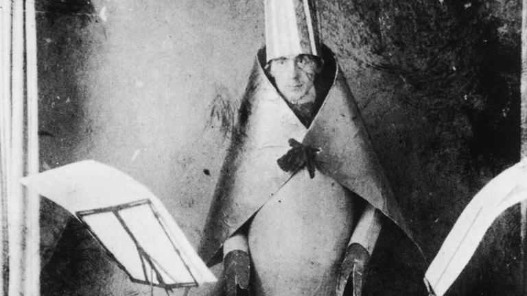 Hugo Ball beim Vortrag seiner "Verse ohne Worte" in selbstgefertigtem kubistischem Kostüm. Hugo Ball beim Vortrag seiner "Verse ohne Worte" in selbstgefertigtem kubistischem Kostüm.