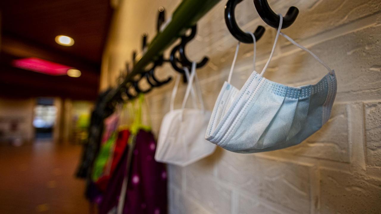 Mundmasken und Jacken hängen im Flur der Schule an einem Kleiderhaken. Die Schulen bleiben während des Corona-Lockdowns geschlossen. Mundmasken und Jacken hängen im Flur der Schule an einem Kleiderhaken. Die Schulen bleiben während des Corona-Lockdowns geschlossen.