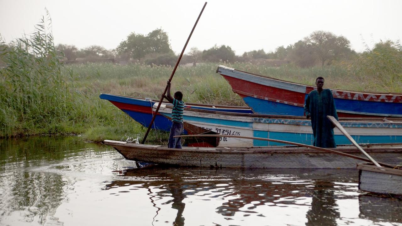 Ein Fischer und sein Sohn legen auf dem Tschadsee am in Baga Sola (Tschad) mit einer Pirogge an.