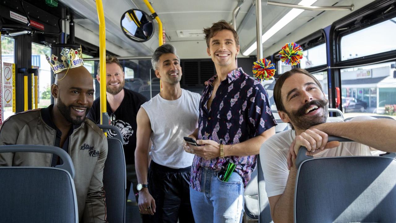 In einem Bus stehen und sitzen in fröhlicher Stimmung die 5 Darsteller der Netflix-Reality-Show "Queer Eye".