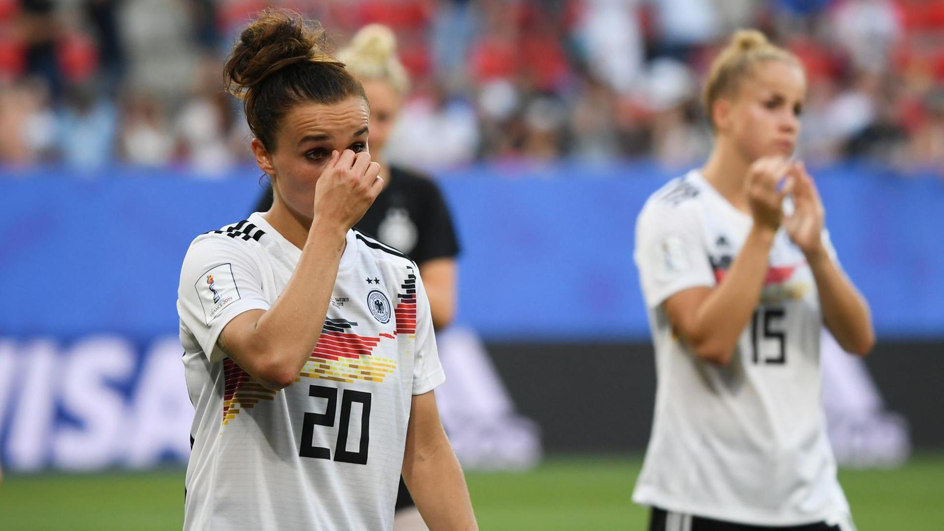 Die deutschen Spielerinnen Lina Magull (links) und Giulia Gwinn gehen nach der Niederlage gegen Schweden enttäuscht über den Rasen. Die deutschen Spielerinnen Lina Magull (links) und Giulia Gwinn gehen nach der Niederlage gegen Schweden enttäuscht über den Rasen.