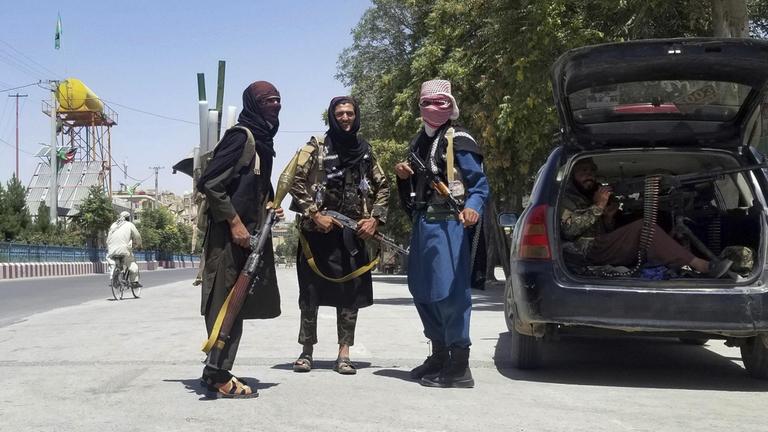 Taliban-Kämpfer posieren schwer bewaffnet vor der Kamera.