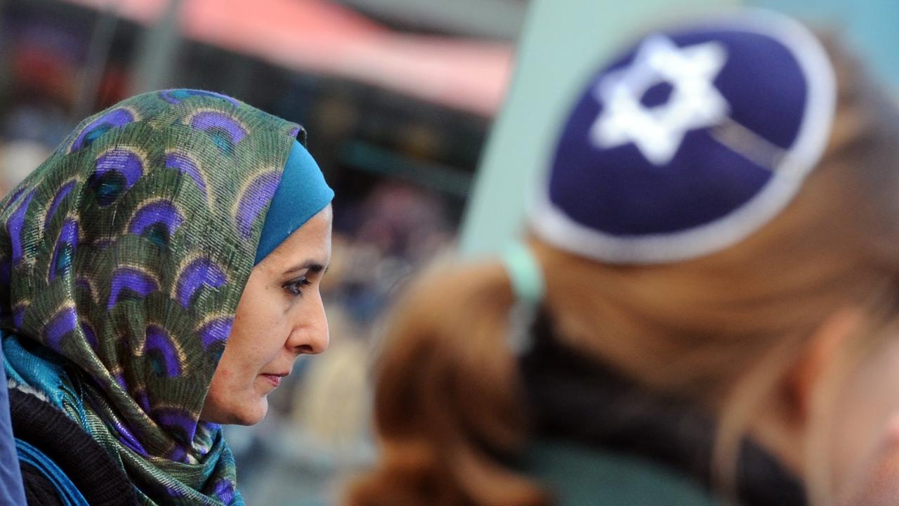 Eine Muslimin mit Kopftuch und eine junge Frau mit Kippa nehmen am Samstag (15.09.2012) in Berlin gemeinsam an einer Demonstration teil.