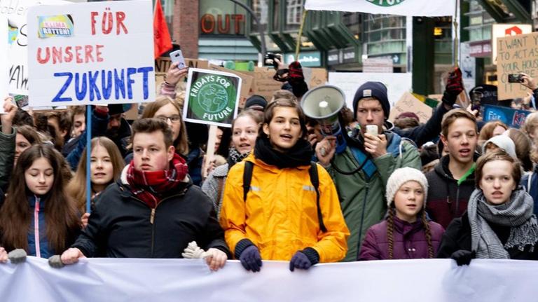 Fridays for Future: Die schwedische Aktivistin Thunberg beim Klimaprotest in Hamburg. Zahlreiche Demonstrantinnen und Demonstranten gehen durch die Straßen und halten ein Transparent vor sich. Fridays for Future: Die schwedische Aktivistin Thunberg beim Klimaprotest in Hamburg. Zahlreiche Demonstrantinnen und Demonstranten gehen durch die Straßen und halten ein Transparent vor sich.