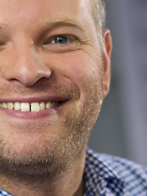 Der Schriftsteller Kristof Magnusson grinst in die Kamera