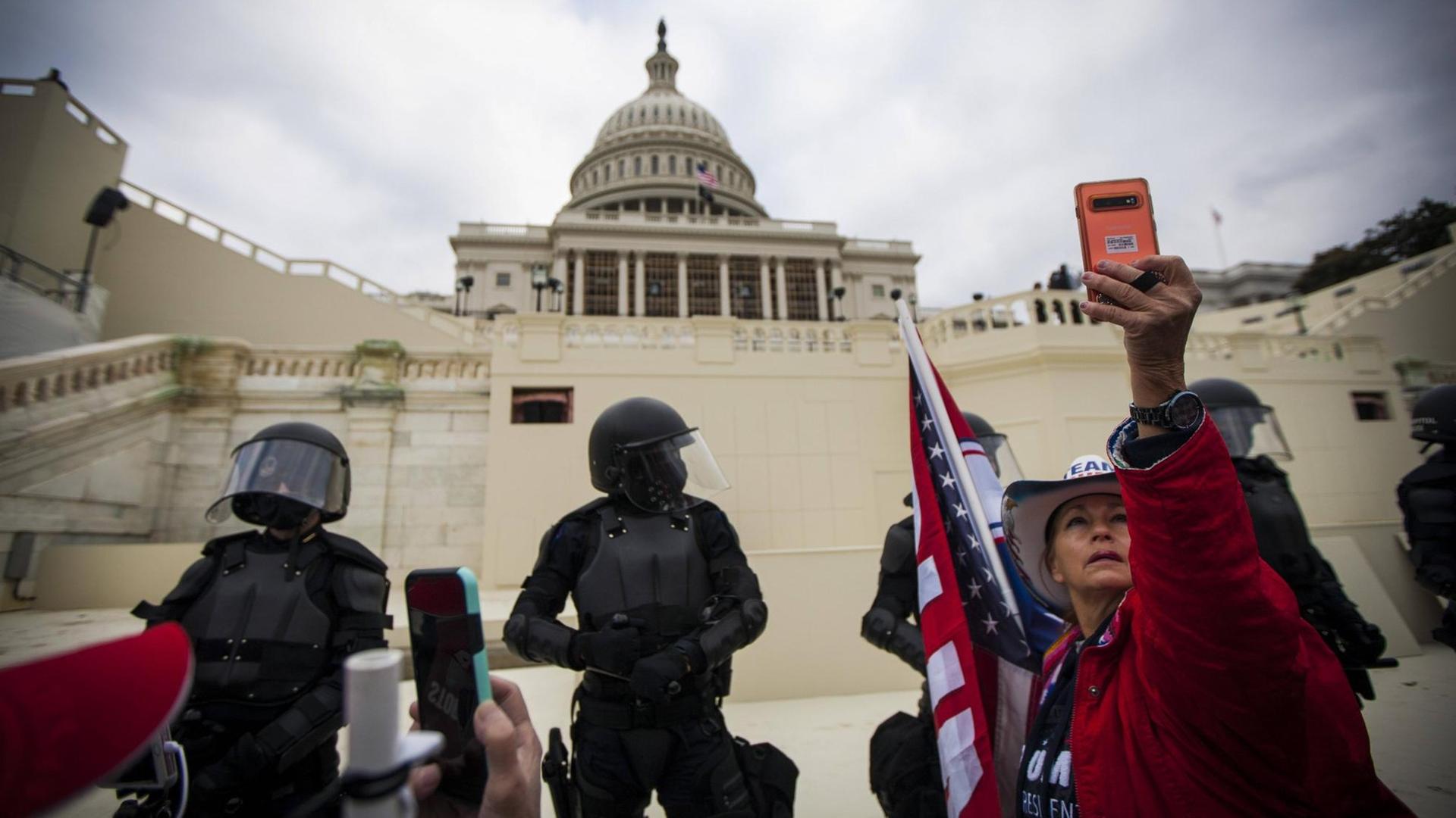 January 6, 2021, Washington Dc, USA: A Trump supporter takes a selfie with Capitol Police in riot gear on Wednesday Jan. 6, 2021 in Washington D.C. Trump supporters stormed the barriers of the US Capitol Building and resulted in a death of a young woman. Washington Dc USA - ZUMAc214 20210106_znp_c214_006 Copyright: xJohnxC.xClarkx