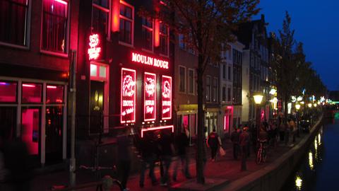 Stadtansicht von Amsterdam, hier das nächtliche Rotlichtviertel mit dem Club Moulin-Rouge am Ufer einer Gracht