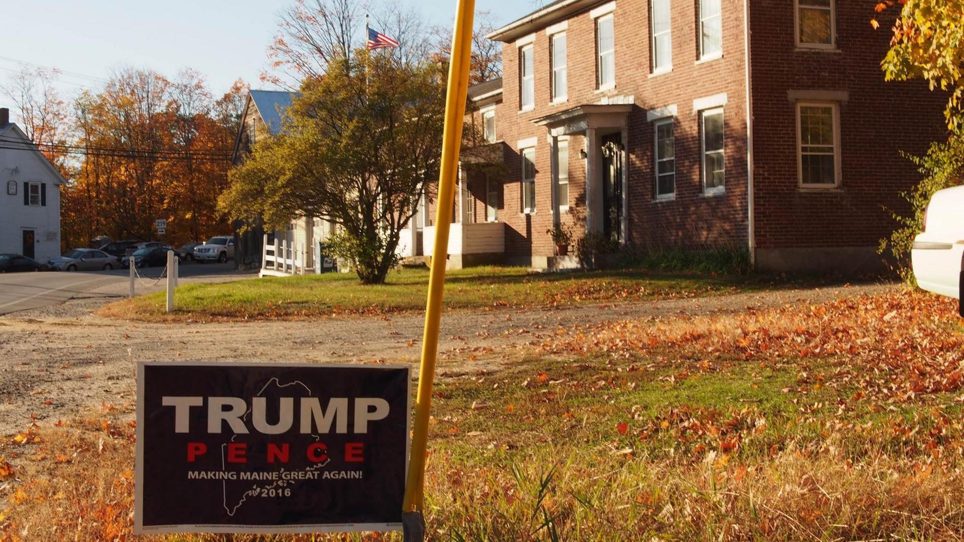 Eine Wohnsiedlung im US-Ostküstenstaat Maine im Herbst. Im Vordergrund ein Wahlplakat für Donald Trump.