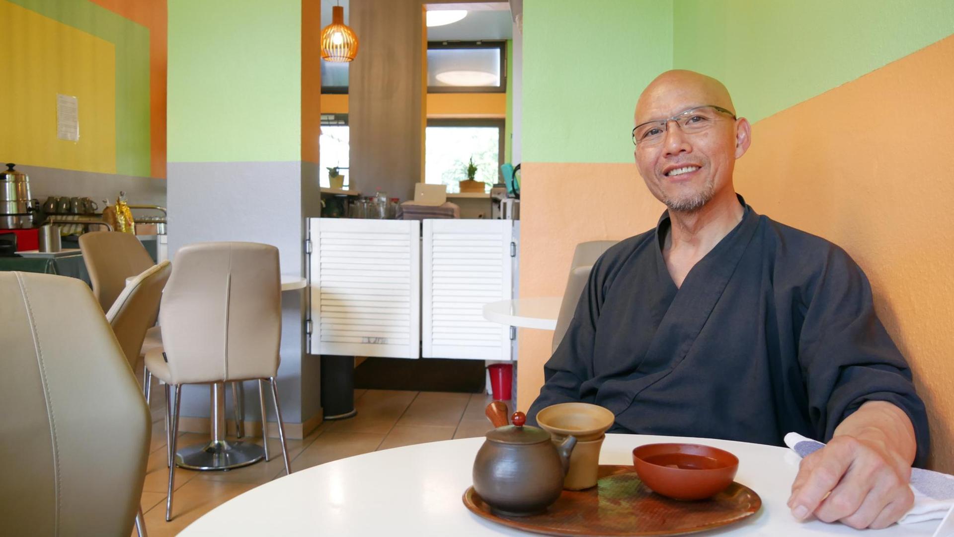 Nguyen Thanh Hieu sitzt in seinem Restaurant an einem Tisch und blickt freundlich in die Kamera Nguyen Thanh Hieu sitzt in seinem Restaurant an einem Tisch und blickt freundlich in die Kamera