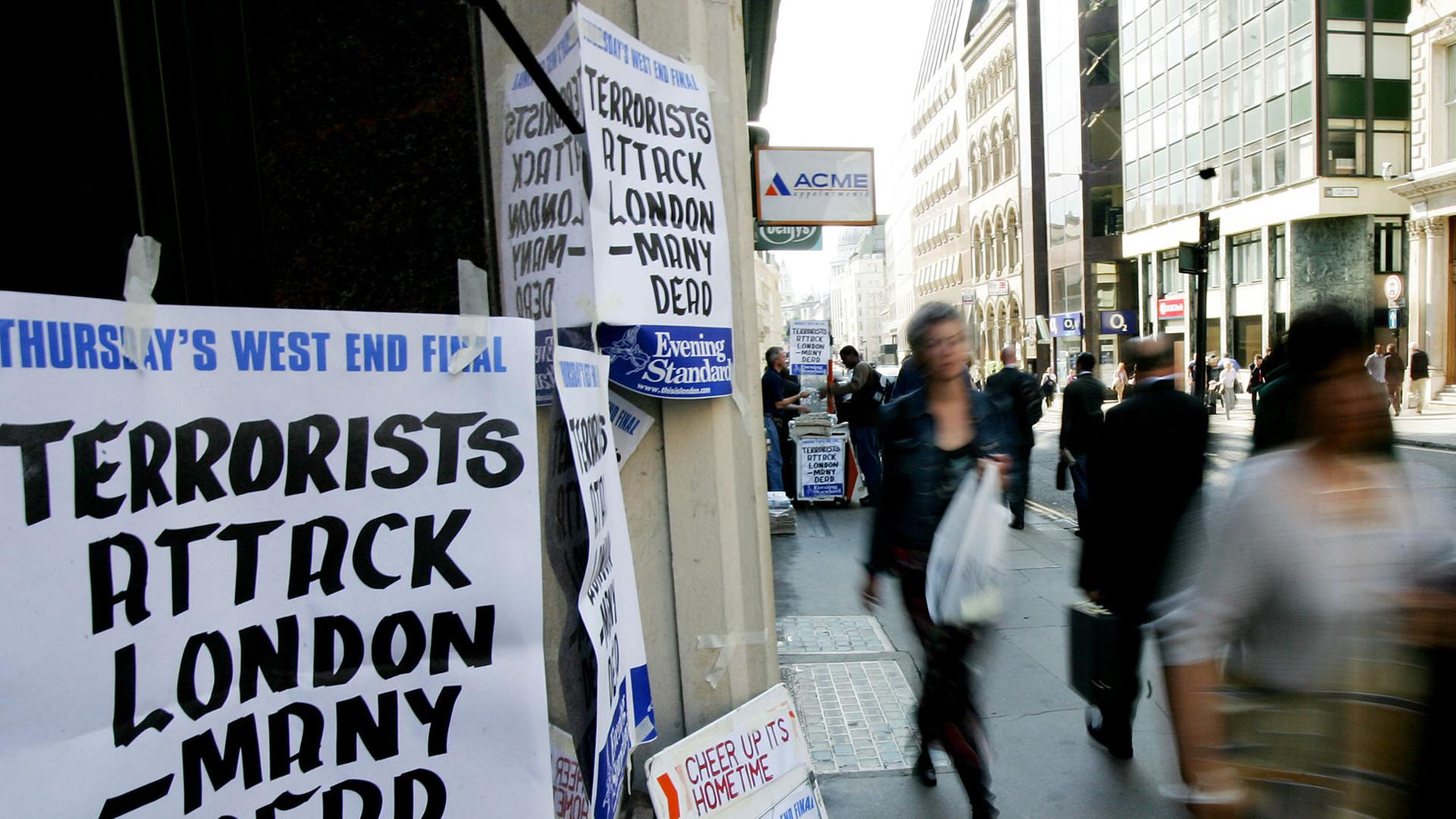 Fußgänger laufen am 07.07.2005 an einem Zeitungsstand vorbei, an dem die Terroranschläge auf die U-Bahn in London angekündigt werden. Fußgänger laufen am 07.07.2005 an einem Zeitungsstand vorbei, an dem die Terroranschläge auf die U-Bahn in London angekündigt werden.