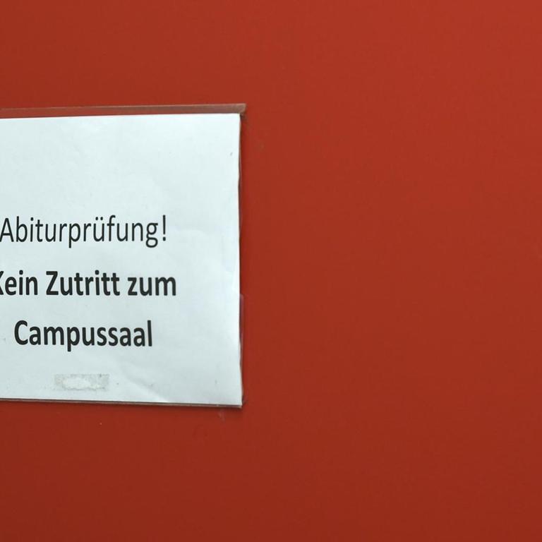 "Achtung Abiturprüfung, bitte leise!"steht an einer Tür zu einem Prüfungsraum einer Schule.